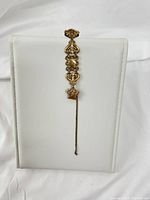 Gold filled watch fob vest chain displayed upright on white stand, showing full length, chain and clip.