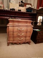 Closed view of the wood jewelry box showing three curved front drawers with gold-tone decorative handles and curved legs.