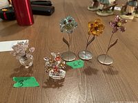 All five crystal flower figurines arranged on tabletop showing size variations