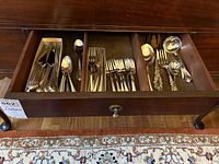 Full drawer view showing assorted flatware arranged in separate compartments.