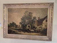 Front view of a framed landscape painting featuring a rural scene with a cottage, people, horses, and sheep.