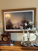 Full view of the framed print showing the maritime scene with ships and the ornate gold frame.
