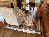 Overall view of rug laid out in living room under furniture.