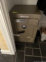 Front view of beige steel safe positioned on tiled floor