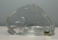 Front and side views of the clear crystal paperweight shaped with a duck and cattails design.