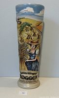 Front view of tall ceramic vessel showing hand-painted woman holding wheat and text 'Schierlinger Roggen'