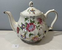 Front and side perspective of the Sadler porcelain teapot with multicolor floral decoration and gold trim on spout, handle, and base.