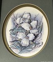 Close up photo of the oval 3D floral artwork showing detailed white trillium flowers and green leaves with purple background shading