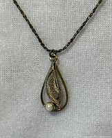 Front view of the VNS sterling silver necklace pendant featuring textured leaf design and pearl detail.