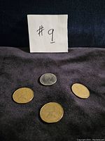 Photo showing obverse side of three 1987 Canadian loonies and one 1976 Canadian 50 cent coin with Queen Elizabeth II portraits visible.
