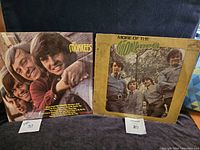 Photo of front covers of two Monkees vinyl albums: 'Meet the Monkees' and 'More of The Monkees'. The 'More of The Monkees' cover is worn and shows discoloration.