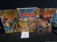 Three comic books side by side showing front covers: Spider-Man motorcycle cover, Archie Laugh beach cover, Spider-Man skating on thin ice cover.