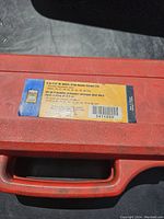 Red plastic carrying case with a label showing the brand 'Proto' and socket set details including size range 25-38 mm and 3/4" drive metric deep impact sockets.