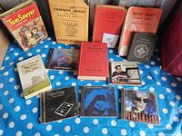 Books and music CDs arranged on a blue cloth with white dots showing titles and covers