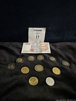 1000 lire banknote front with portrait, displayed with various coins including bimetallic 500 lire coins and other smaller denomination coins