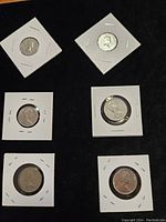 Six Canadian coins: 1960, 1961, 1968 nickels; 1971, 1973, 1977 quarters, each in individual cardboard holders with clear windows.