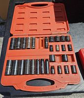 Opened orange plastic case showing organized Power Fist sockets of various sizes.
