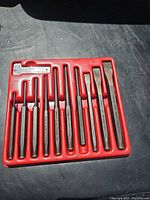 Red molded tray filled with 11 steel tools