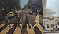 Iconic Abbey Road album cover photo showing The Beatles walking across a zebra crossing on Abbey Road.