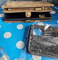 Closeup of brown wallet-style Samsung phone case with zipper and snap