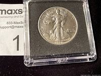 Close-up photo of a 1936 Walking Liberty half dollar coin in a protective case showing the obverse side featuring Lady Liberty walking towards the rising sun.