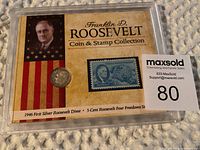 Protective display case containing a 1946 first silver Roosevelt dime and a blue 5-cent Roosevelt Four Freedoms stamp with Roosevelt portrait and USA flag background.