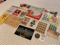 Wide view showing all vintage collectible items including stamps, coins, toy trucks, postcards, and paper memorabilia.