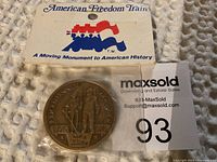 Token front view inside sealed original packaging with cardboard header displaying American Freedom Train logo.
