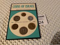 Front view of the 1967 Jerusalem Specimen Set packaging showing six coins arranged in circular formations mounted in white insert with turquoise background and black border.