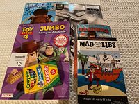 Photo of four children's activity and coloring books alongside a box of Crayola crayons.