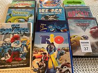 Photo showing a group of 9 DVDs including The Smurfs, Shrek, Ice Age: Continental Drift, The Ant Bully, Wreck-It Ralph, Cars 2, Rio, and others.