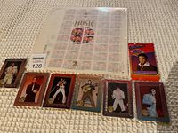 Photo showing all items including the Elvis Presley commemorative stamp sheet, 7 individual collectible cards in front, and a pack of Elvis Presley trading cards on the right.
