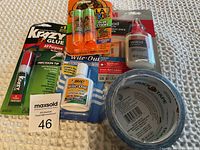 Photo of all adhesive and correction fluid products including Krazy Glue, two Bic White-Outs, LA Kids glue sticks, Elmer's wood glue, and Duck Tape roll