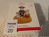 Photo of the Hallmark Keepsake ornament box showing the cow and two chickens on a base, labeled as MOO-EY Christmas with magic sound and motion.
