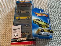 Multi-pack set of five Hot Wheels Mustang cars and a single yellow Hot Wheels 1967 Mustang GT car in packaging