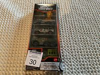 Front view of Jurassic World Matchbox three vehicle set in original packaging with bottom corner damage.