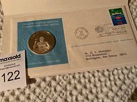 Official United Nations commemorative silver medal mounted on blue card with laurel wreath design, First Edition Proof text, and original envelope with First Day of Issue postal stamp dated 1974-11-22 from United Nations, New York.