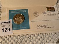 Silver commemorative medal displayed on a card with official envelope and postmark dated October 24, 1974, certifying authenticity and first day issue.
