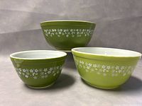Front view of the three nested bowls showing varying green shades and white floral exterior pattern