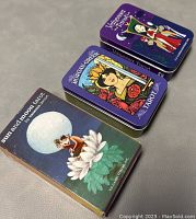 Three tarot card sets: two in tin boxes (Morgan Greer, Vanessa) and one in cardboard box (Sun and Moon).