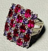 Close-up view of the rectangular cocktail ring top showing red oval and purple round crystals set in 925 silver with prong settings.
