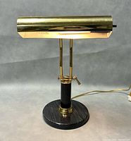 Front view of vintage brass piano lamp showing marble base and brass adjustable hood