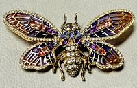 Front view of the vintage Anne Klein butterfly brooch showing colorful enamel wings with purple, pink, orange tones, and clear crystals outlining the butterfly shape.