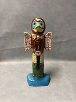Front view of ceramic totem pole liquor bottle showing detailed facial features and wings.