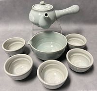 Full tea set arranged with kyusu teapot, pitcher, and five teacups