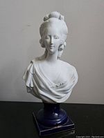 Front view of the white bisque porcelain bust of Marie Antoinette showing detailed facial features and upper torso on the deep blue porcelain base.