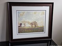 Framed print showing the full piece on a black surface with a dark wood frame.