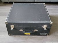 Closed Ludwig music case showing black exterior with silver latches, corners, and handle with stitching detail.