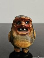 Front view of the hand carved wooden troll showing facial features and wood grain details