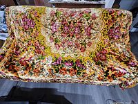 Wide view of large velvet blanket spread out, showing full floral and lace pattern with mustard yellow background.